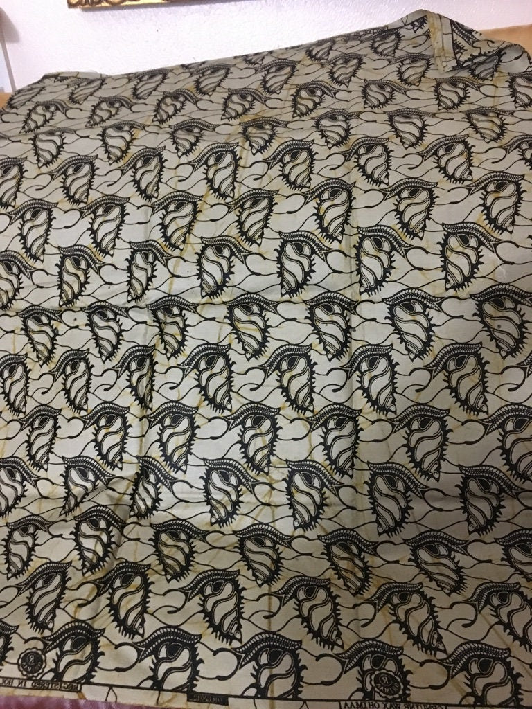 African fabric sold per yard.  Beige and black Colour